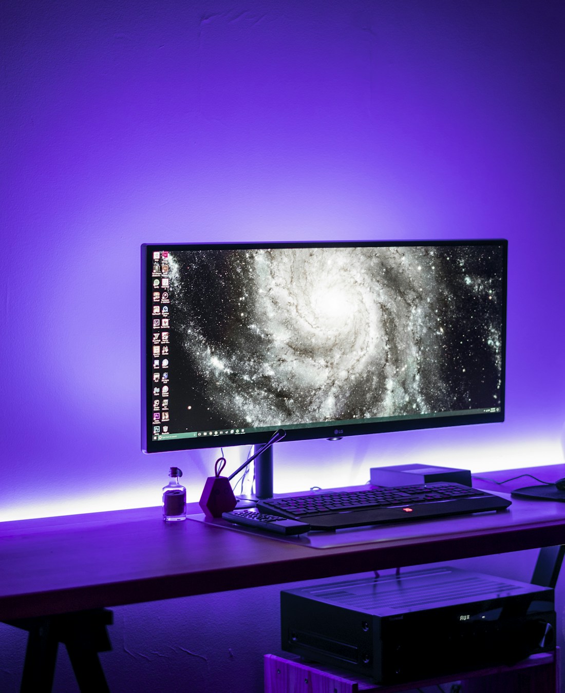 A desktop workspace lit with soft violet ambient light